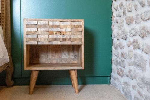 a small wooden stool sitting next to a wall at The Sheep and Penguin in Wells