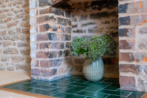 a vase with a plant in a brick wall at The Sheep and Penguin in Wells