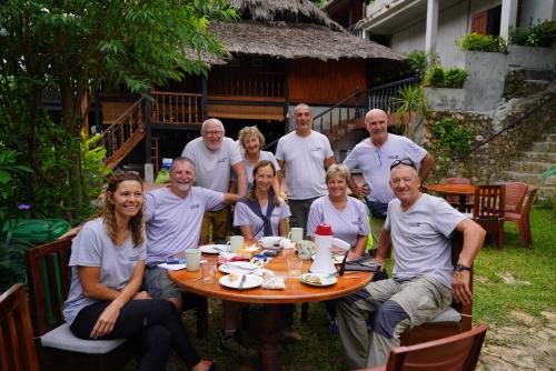 a group of people sitting around a table at Ba Be Jungle Houses in Ba Be