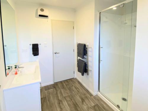 a bathroom with a shower and a sink at 4bed 2bath house 5 mins walk to Palms & Golf club in Christchurch