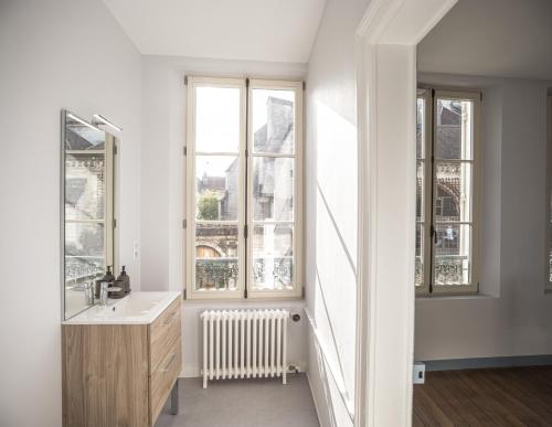 une salle de bain avec un lavabo et deux fenêtres dans l'établissement Chez Suzanne 1 - Chambre Privée dans Maison de Ville - Confort - Hypercentre, à Troyes
