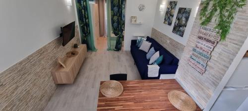 ein Wohnzimmer mit einem blauen Sofa und einem Tisch in der Unterkunft Monolocale Splendida casa vacanze in Tenerife del Sur Casa Mimì in Arona