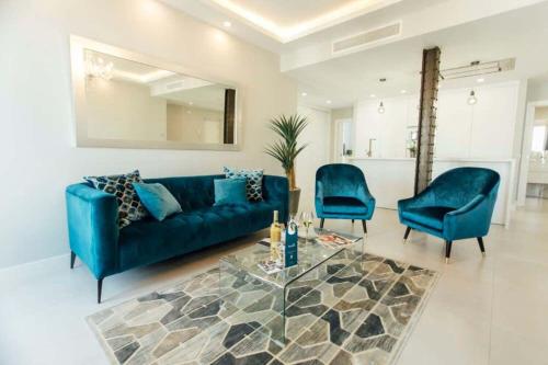 - un salon avec un canapé bleu et deux chaises dans l'établissement Modern and luxurious -3 Bdr 2Bth- Pastor y Landero, à Séville