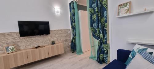 ein Wohnzimmer mit einem Flachbild-TV an der Wand in der Unterkunft Monolocale Splendida casa vacanze in Tenerife del Sur Casa Mimì in Arona