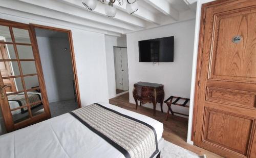 um quarto com uma cama e uma televisão na parede em Hotel Dandy Rouen centre em Rouen
