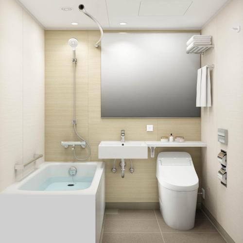 a bathroom with a tub and a toilet and a sink at JR Kyushu Station Hotel Kokura in Kitakyushu