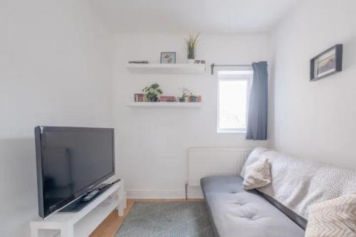 a living room with a couch and a flat screen tv at Stylish & Homely 1BD Flat - Walthamstow! in London