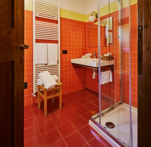 a bathroom with orange tiles and a sink and a shower at Agriturismo Cascina Mirandola in Como