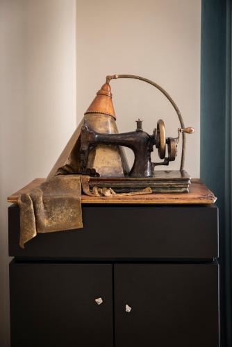 an old sewing machine sitting on top of a dresser at Atelier Inès Arts & Suites in Naples
