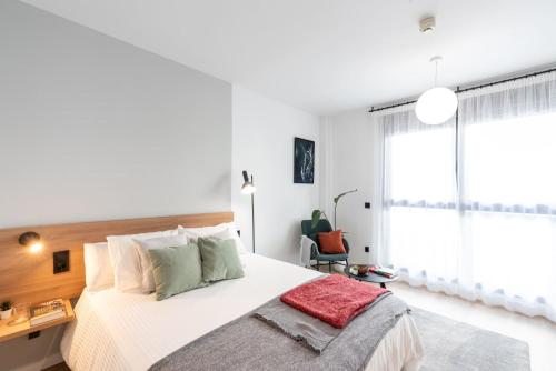 a bedroom with a large bed and a window at Be Casa - San Sebastian de los Reyes in San Sebastián de los Reyes