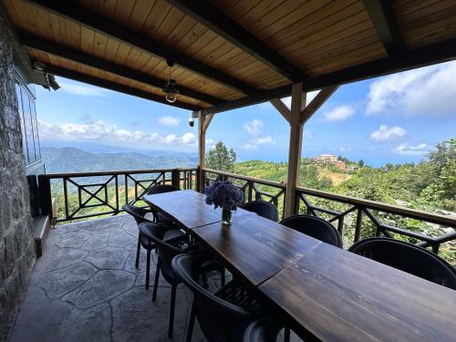 una mesa de madera y sillas en un balcón con vistas en VİRA TAŞ KONAK, en Trabzon