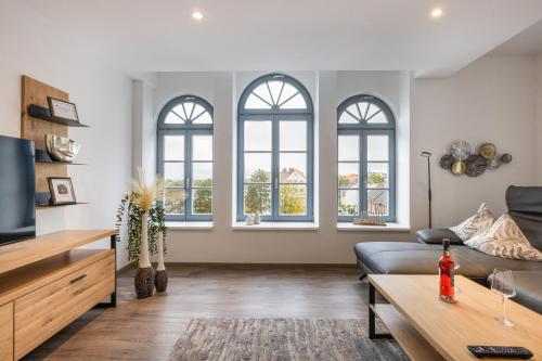 uma sala de estar com três janelas e um sofá em Bed & Bahn Seesen em Seesen
