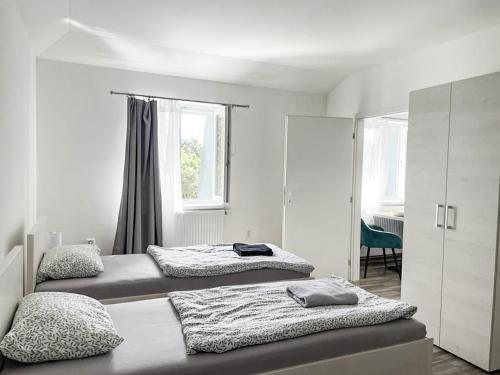 2 camas en una habitación con 2 ventanas en Apartmány Plzeň Zábělá 69, en Plzeň
