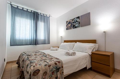 una camera da letto con un letto e due asciugamani di INMUEBLE DE CATEGORIA. Wifi FREE a L'Escala