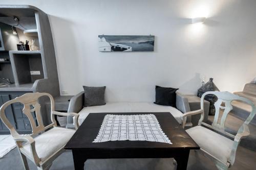 a living room with a couch and a table and chairs at Lotza Studios in Oia