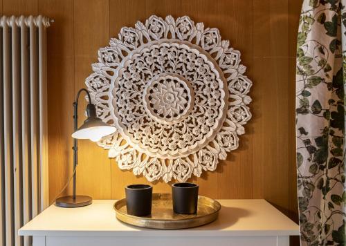 a table with a lamp and a plate on a wall at Capanna in Wildhaus