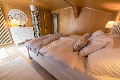 a bedroom with a large bed and a white dresser at Capanna in Wildhaus