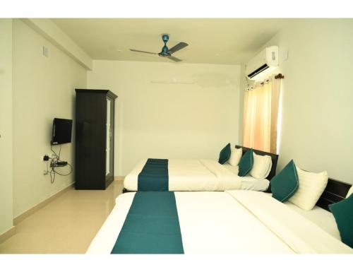 ブバネーシュワルにあるMy Homes and Hotels, Bhubaneswar, Odishaのベッド2台、天井ファンが備わる客室です。