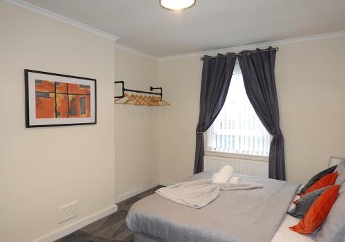 um quarto com uma cama e uma janela em Welsh Drive Apartment by Klass Living Blantyre em High Blantyre