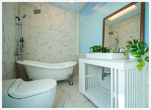uma casa de banho com uma banheira, um WC e um lavatório. em My Ocean Villa 月牙桐海景民宿 em Ruifang
