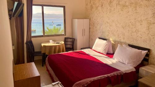 a bedroom with a bed with a view of the ocean at Al-Amer Hostel 2 in Aqaba