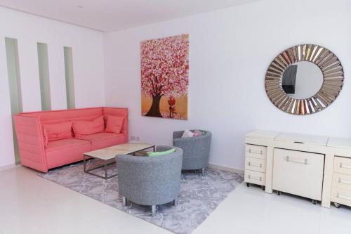 a living room with a red couch and a mirror at Private 5 Bed Villa / Next to Lagoon in Seeb