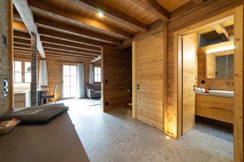 Zimmer mit Holzwänden und einer Küche mit einem Tisch in der Unterkunft Chalet Selun in Wildhaus