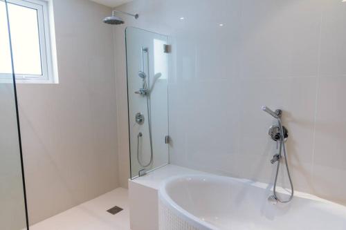 a white bathroom with a shower and a tub at Private 5 Bed Villa / Next to Lagoon in Seeb