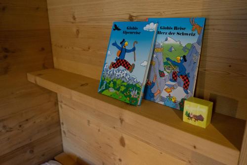 two childrens books sitting on a shelf in a room at Chalet Selun in Wildhaus