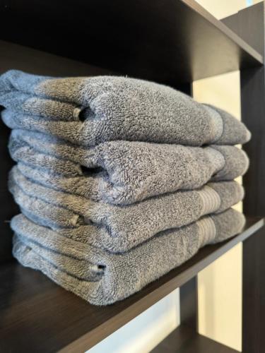 a pile of towels sitting on a shelf at Reen's Cosy Place in Cyberjaya