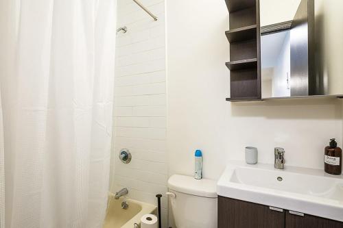 uma casa de banho com um lavatório, um WC e um chuveiro em Apartment 189: Upper East Side em Nova York