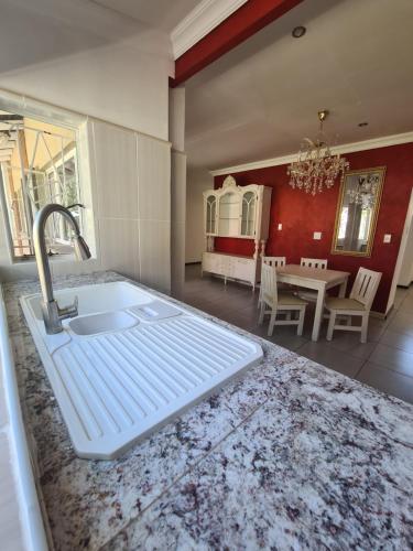 uma cozinha com um lavatório e uma sala de jantar em @336 Bourke em Pretoria