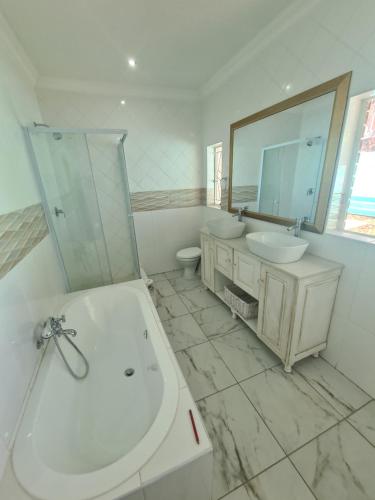 a white bathroom with two sinks and a mirror at @336 Bourke in Pretoria