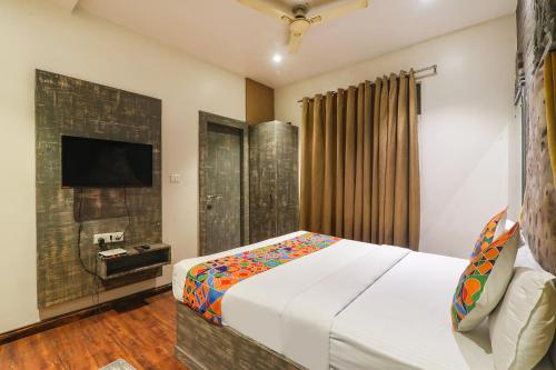 a bedroom with a bed and a flat screen tv at FabExpress Stay Inn I in Muthiganj