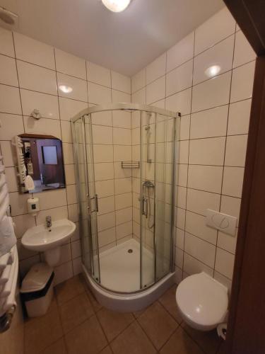 a bathroom with a shower and a toilet and a sink at Hotel Parkowy in Malbork