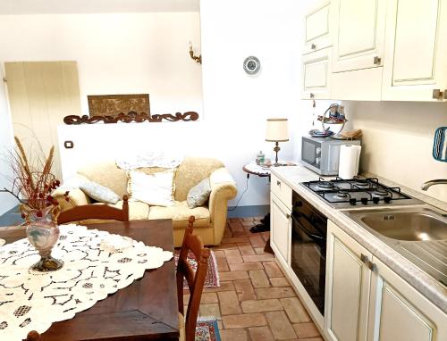 uma cozinha com uma mesa e um fogão forno superior em Appartamento elegante em Morciano di Romagna