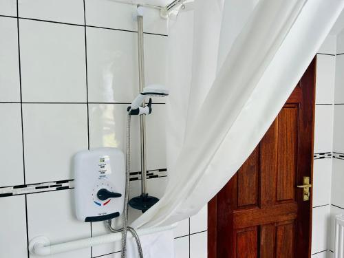 a white shower curtain in a bathroom with a hair dryer at Elmbank Avenue House by Klass Living Uddingston in Uddingston