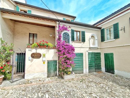 una casa con flores a un lado. en Appartamento elegante, en Morciano di Romagna