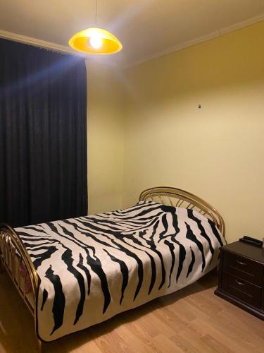uma cama com estampa de zebra num quarto com uma janela em Homes em Tsqnetʼi
