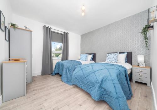 1 dormitorio con 2 camas y ventana en Sanderson Apartment by Klass Living Uddingston, en Uddingston