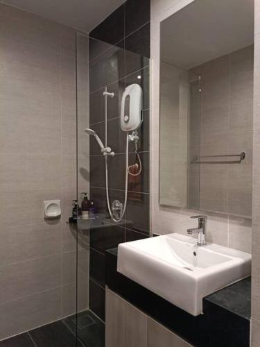 La salle de bains est pourvue d'un lavabo et d'une douche avec un miroir. dans l'établissement Cozy Studio Retreat @Queenville Bandar Permaisuri, à Kuala Lumpur