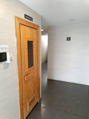 - un couloir avec une porte en bois dans l'établissement Cozy Studio Retreat @Queenville Bandar Permaisuri, à Kuala Lumpur
