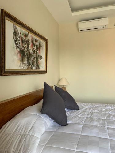 a bedroom with a bed with two pillows at Londo House in Ubud