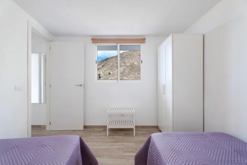 biały pokój z 2 łóżkami i oknem w obiekcie Vivienda vacacional La Era w mieście Vallehermoso
