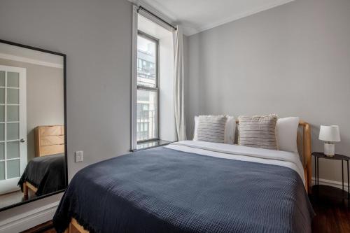 a bedroom with a large bed and a large window at East Village 2br w wd nr groceries NYC-1261 in New York