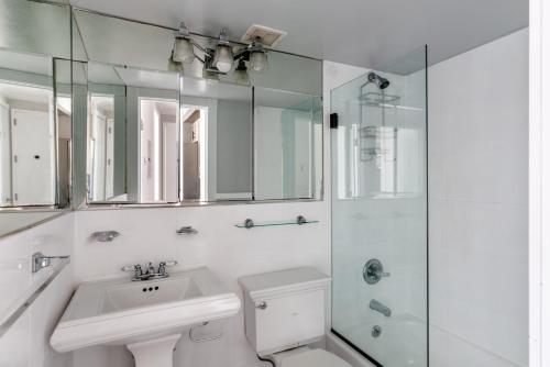 a white bathroom with a sink and a shower at East Village 2br w wd nr groceries NYC-1261 in New York