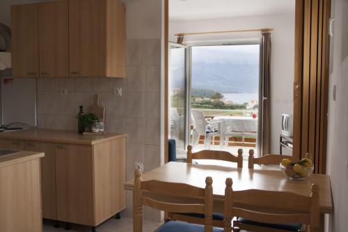 a kitchen with a table and a view of the ocean at House Baglija in Lumbarda
