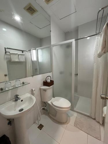 a bathroom with a toilet and a shower and a sink at Sierra Hotel in Dumaguete
