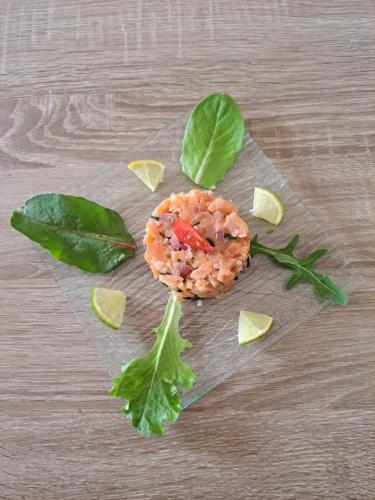 a table topped with a food item with green leaves at La Barde Montfort, votre maison d'hôtes à 4 kms de Sarlat Dordogne in Vitrac