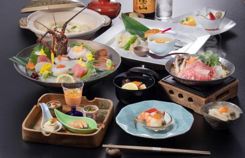Wakayama Marina City Hotel في واكاياما: طاولة مليئة بأطباق الطعام وأوعية الطعام